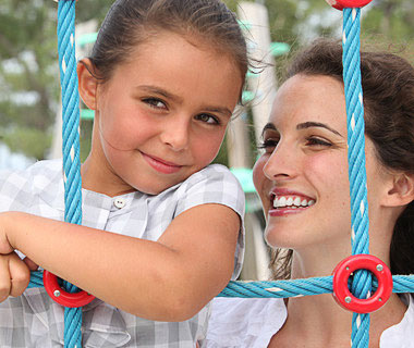 In the photo, a mother is holding her female kid, and both women are attractive.