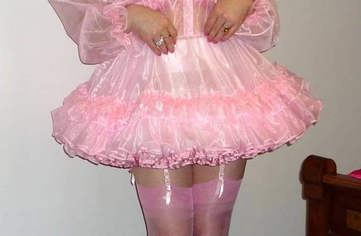 The boy was dressed in a pink sissy adult dress, high-heeled slippers, and stocks.