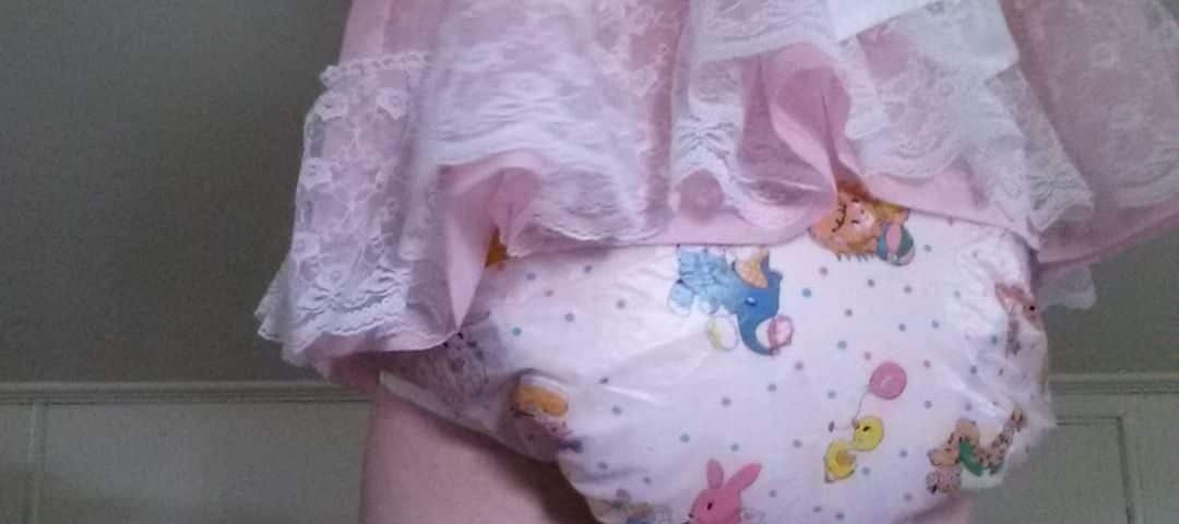 For the photo session, a Diaper Sissy is positioned on the ground while standing.