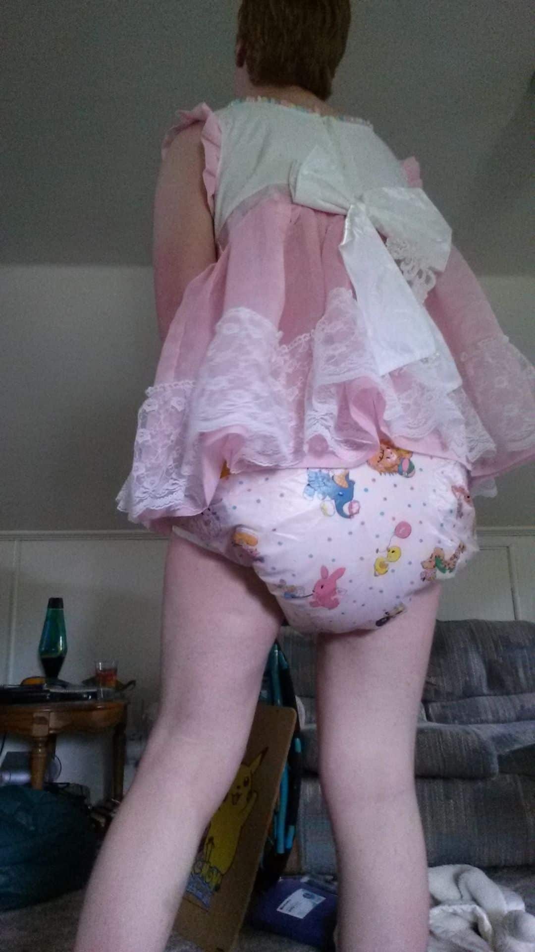 For the photo session, a Diaper Sissy is positioned on the ground while standing.
