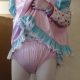 Near the wall, a Diaper Man is standing and sporting a white baby girl suit.