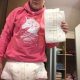 A man who loves diapers is standing on the ground while donning a pink dress and a diaper.