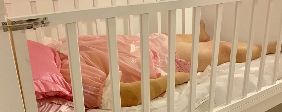 A man is lying on the Sissy Baby Crib, which is maintained in the room.