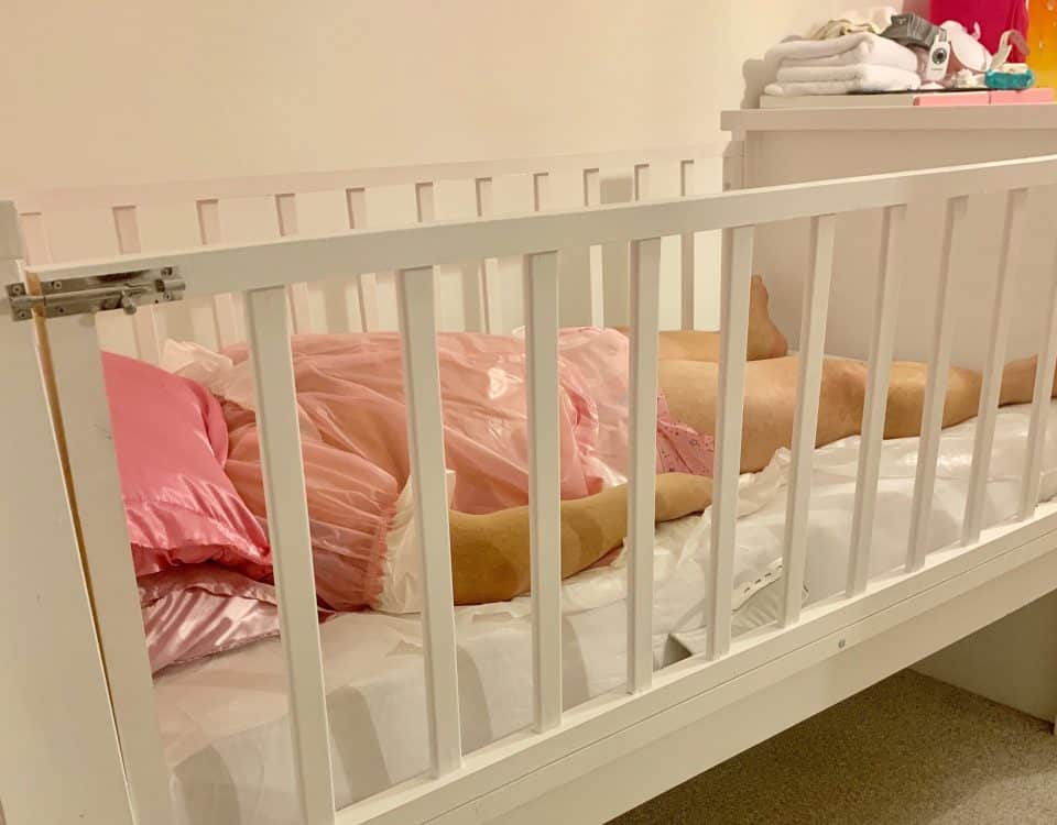 A man is lying on the Sissy Baby Crib, which is maintained in the room.