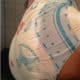 Standing on the ground, a Diaper Butt man is donning a large white diaper.