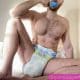 Sitting on the ground, a Diaper Lover is sucking the baby's nipple.