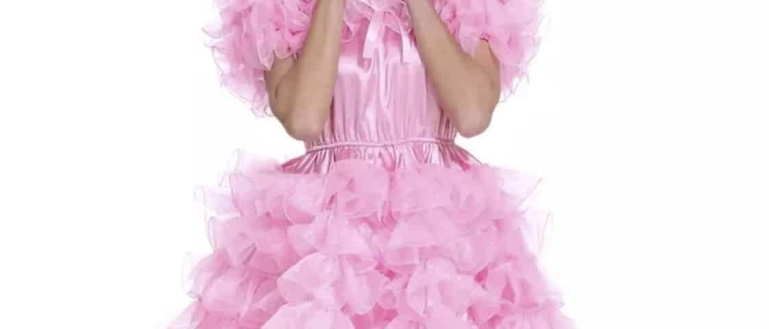 Standing for the photo shoot, the diaper fetish girl is donning a pink gown with frills.